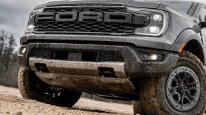 2025 Ford Ranger Raptor driving off-road with dust trail behind