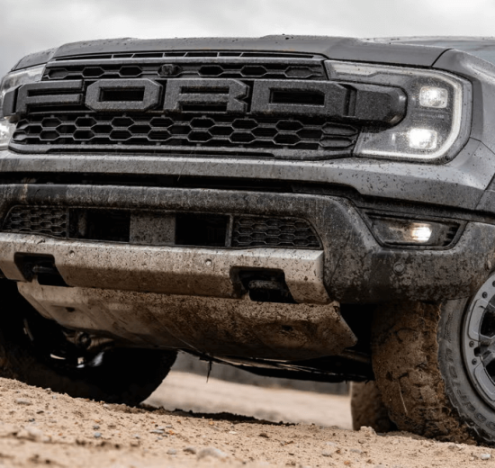 2025 Ford Ranger Raptor driving off-road with dust trail behind