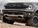 2025 Ford Ranger Raptor driving off-road with dust trail behind