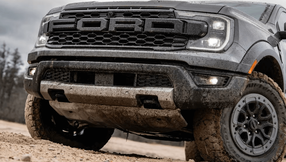 2025 Ford Ranger Raptor driving off-road with dust trail behind